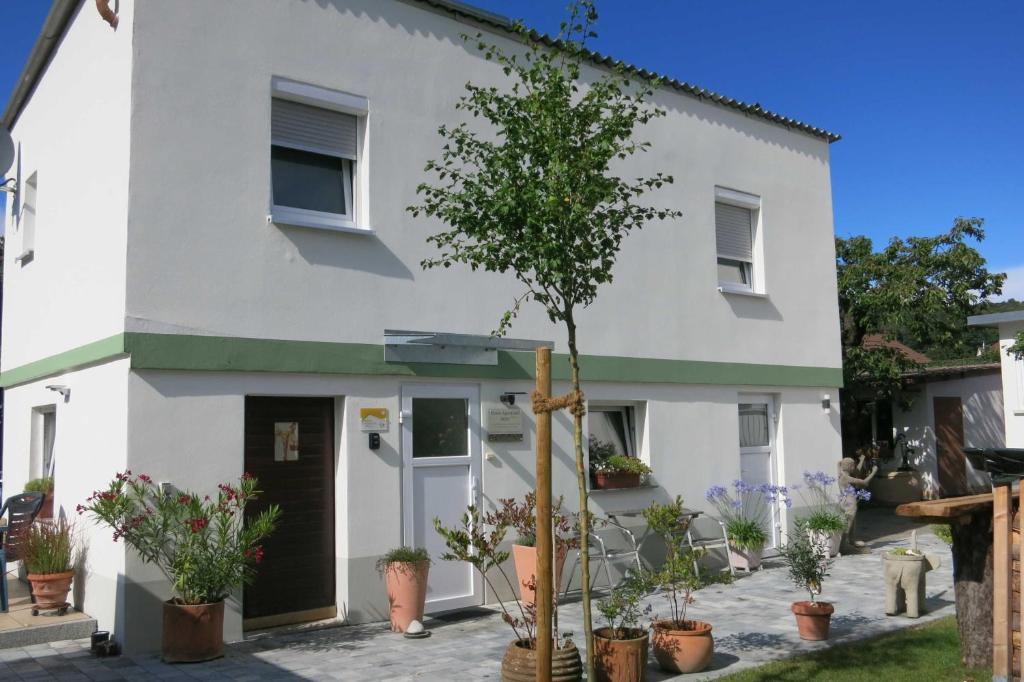 a white house with a tree in front of it at Ferien-Apartment Beller in Strullendorf