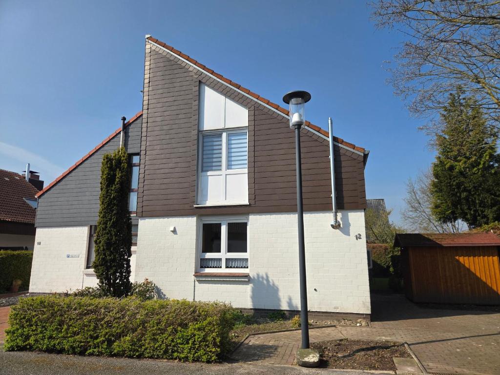 a house with a street light in front of it at Nr 64 - Ferienhaus Krabbe 12 in Carolinensiel