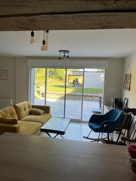 a living room with a couch and chairs and a large window at Chez Paulette - par Happy House in Gouzon