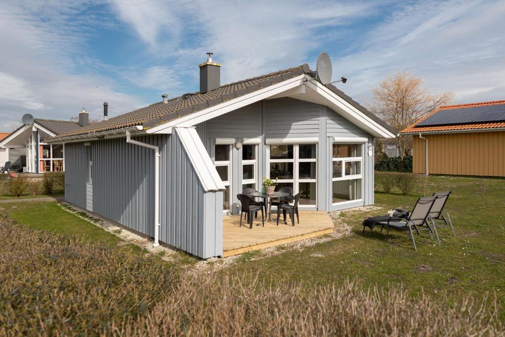 a shed with a table and chairs in a yard at Ferienhaus Strandpark 41 in Grömitz