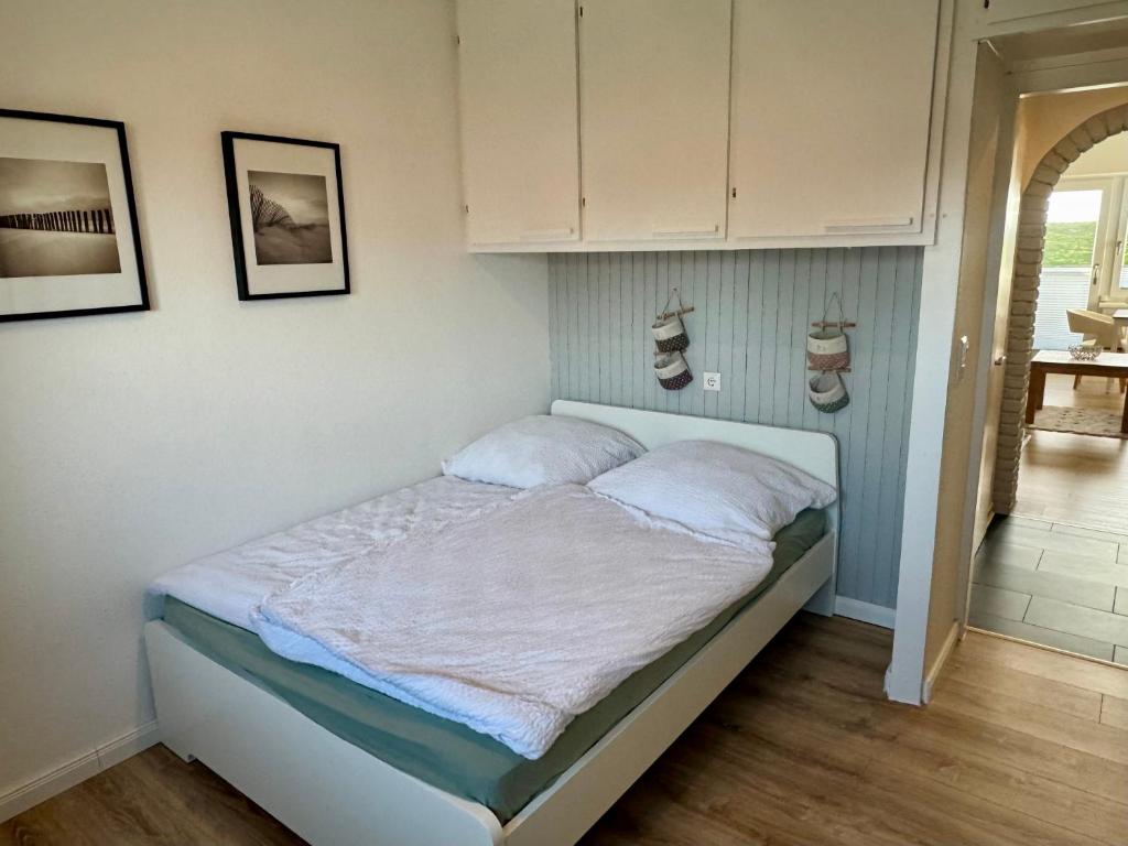 a bed in a bedroom with shoes on the wall at Haus Lith - Ferienwohnung Strandläufer in Nordstrand