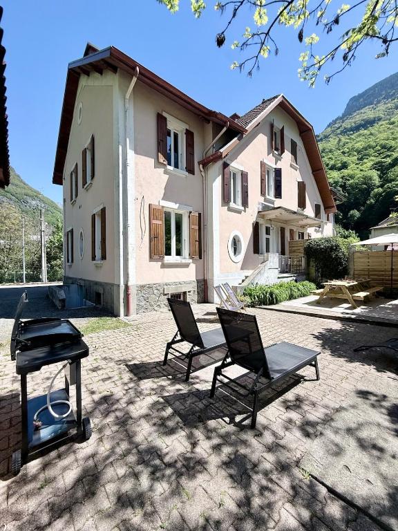 a house with two chairs and a grill in a yard at L'escale de l'oisans in Livet-et-Gavet