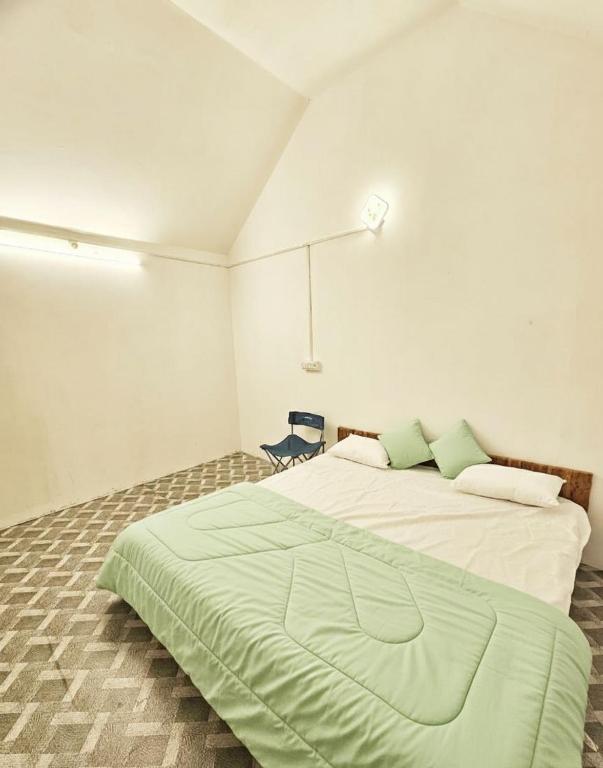 a bedroom with a large bed with a green blanket at The Canvo Vattavada Private Cottages in Vattavada
