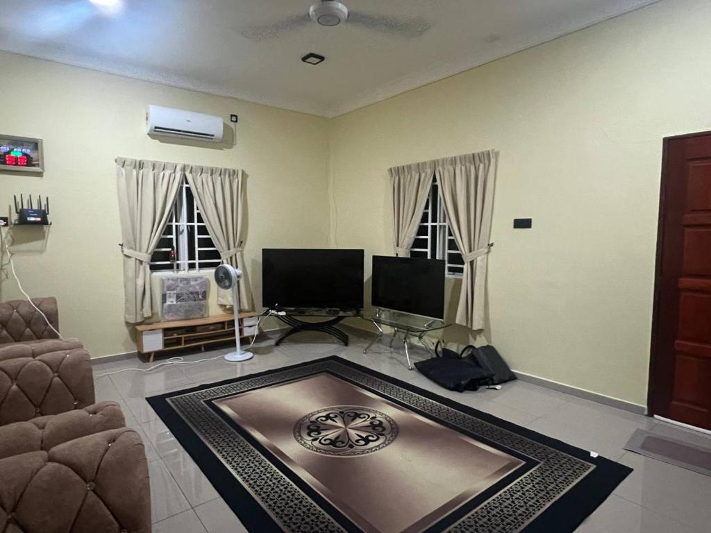 a living room with two windows and a table at Homestay Abah in Bidur