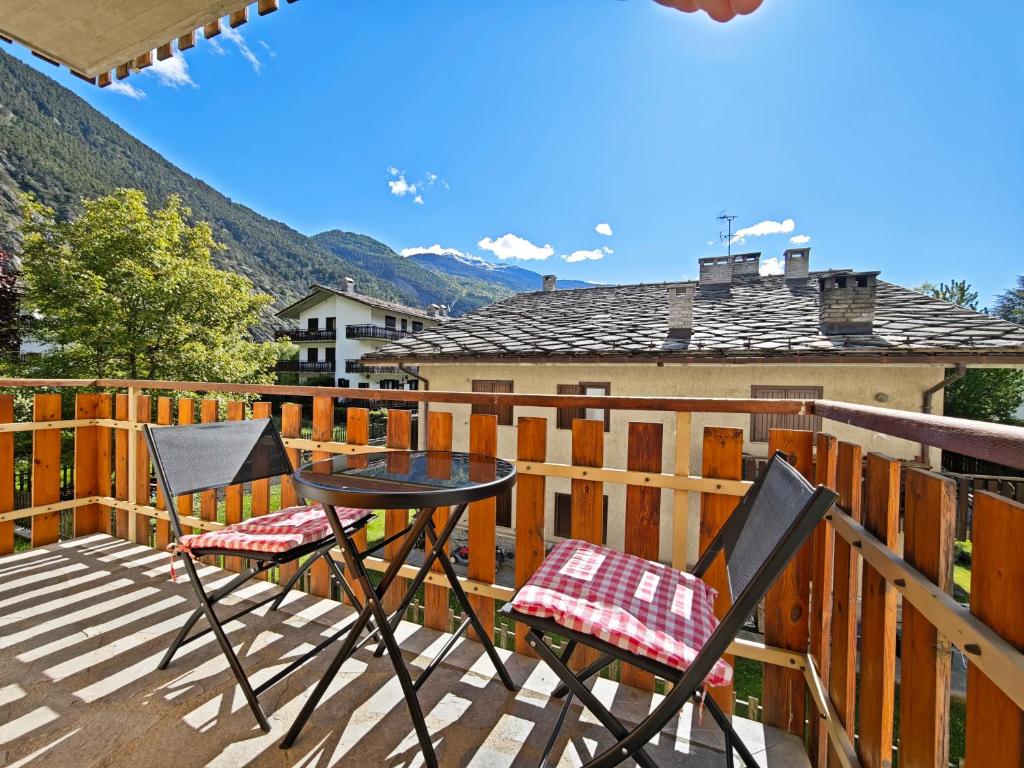 a patio with two chairs and a table on a deck at Il Nido al Noce in Morgex