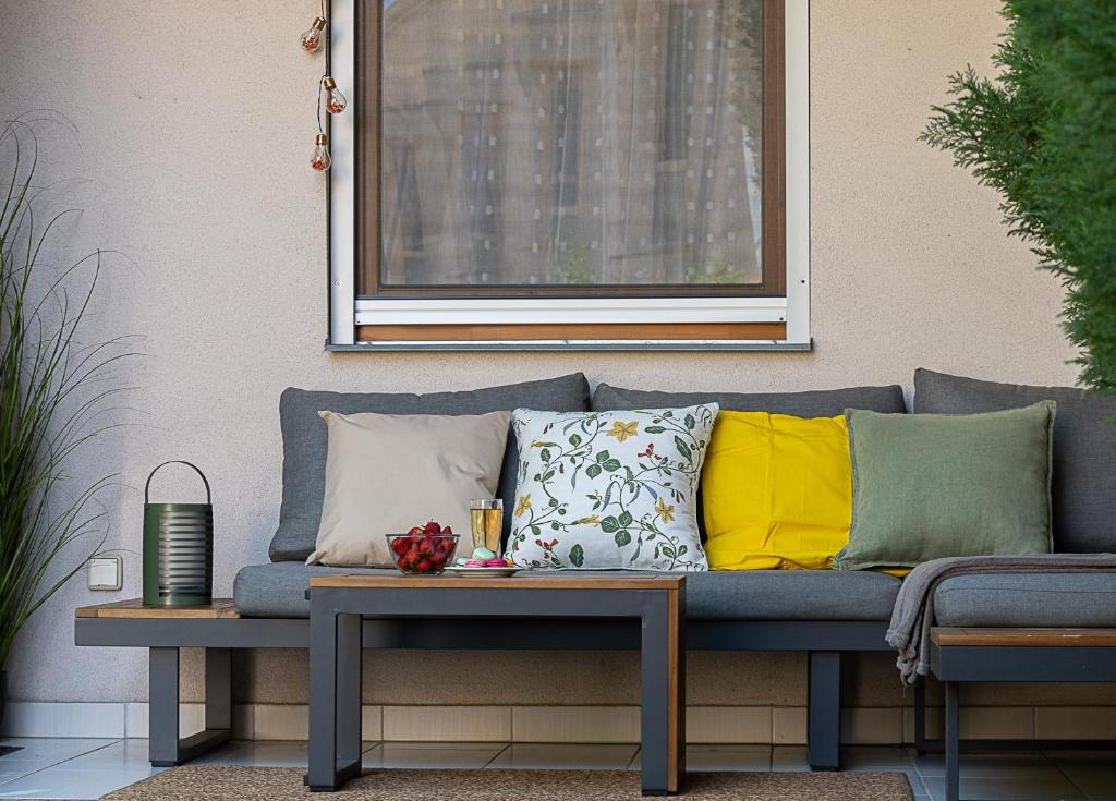 a blue couch with pillows and a table at Six Corners Garden Corner with Terrace and Parking in Pécs