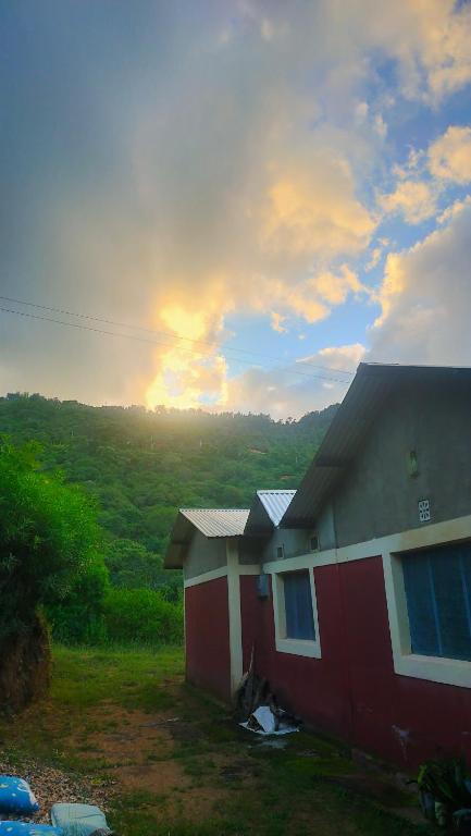 a house with the sunset in the background at Sere n' Lukundo Park & Camping Services in Voi