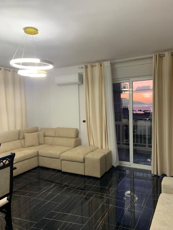 a living room with a couch and a large window at Luna Mare Apartments in Orikum