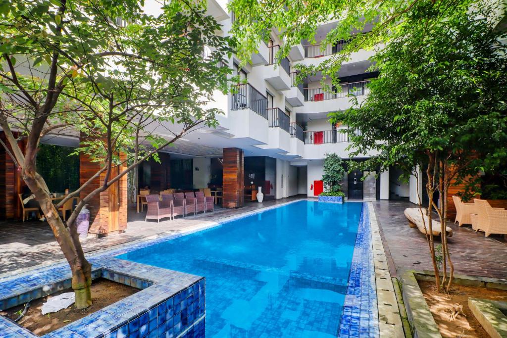 a swimming pool in front of a building at Palette Hotel Seminyak in Seminyak