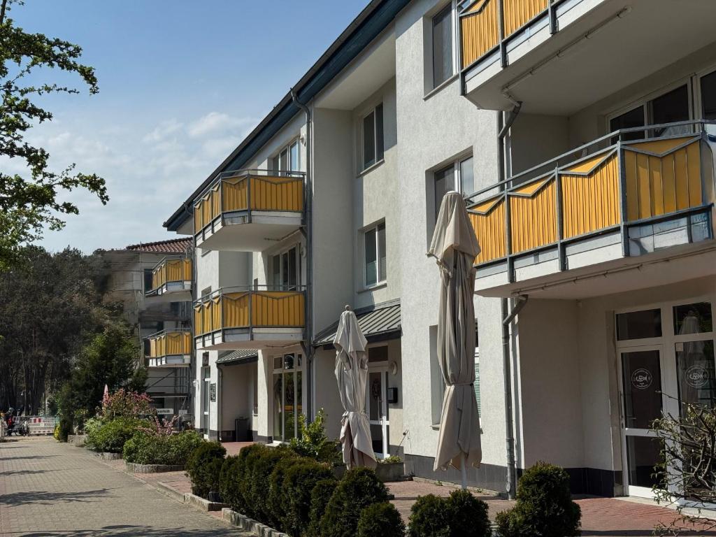 an apartment building with two umbrellas in front of it at Ferienwohnung Quartier18-09 strandnah in Karlshagen