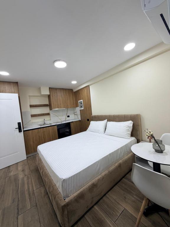 a bedroom with a large white bed and a desk at EDEAN Apartments 4 in Tirana
