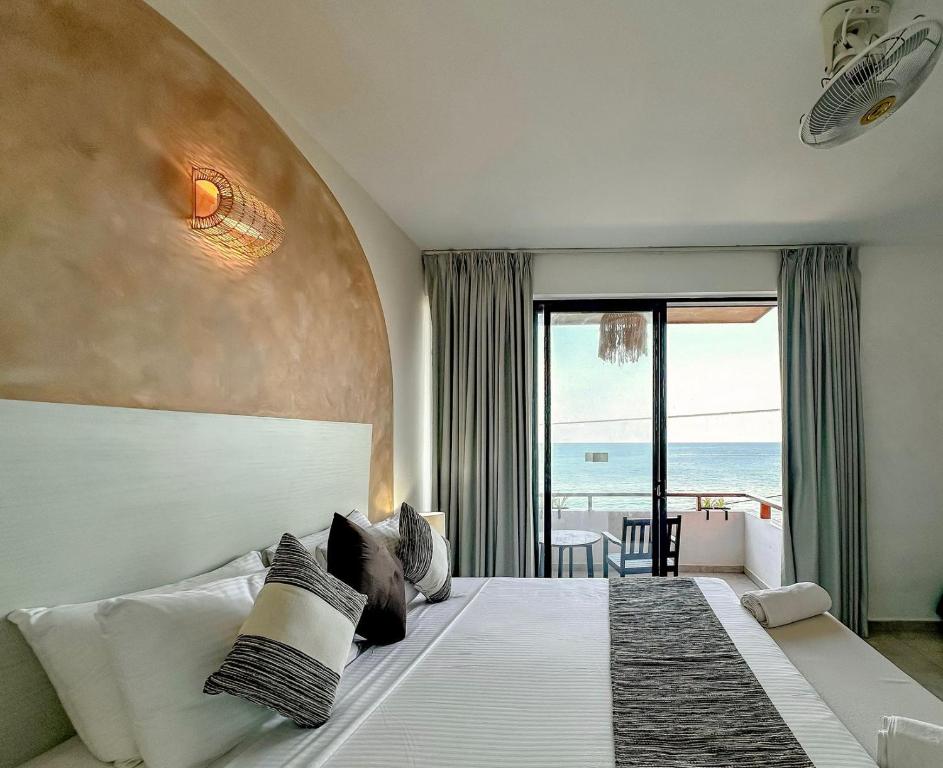 a bedroom with a bed with a view of the ocean at Linará in Hikkaduwa