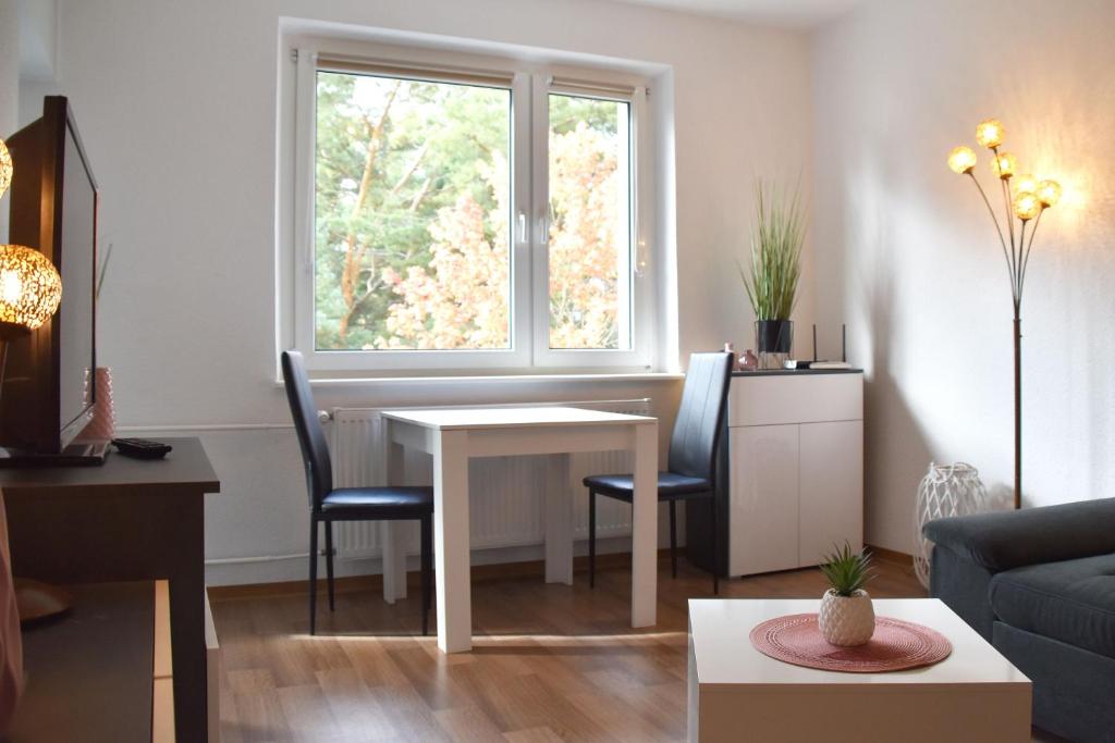 a living room with a table and a window at GUWO Gästewohnung Goethestraße 82d in Guben