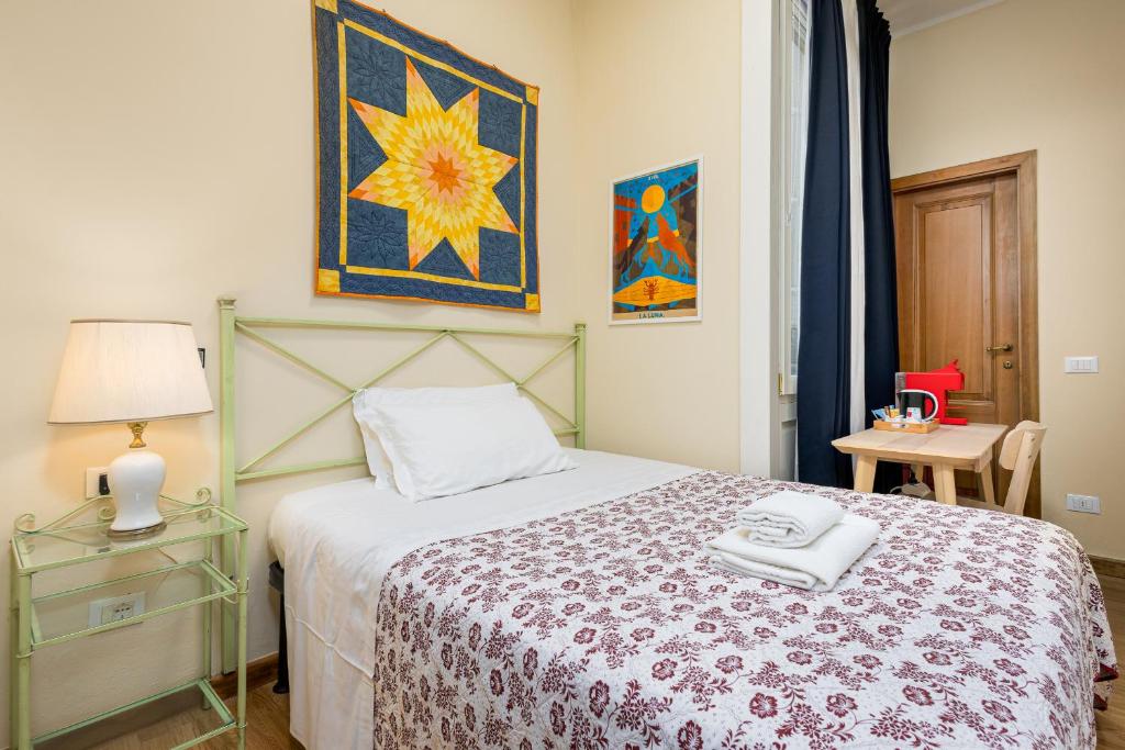 a bedroom with a bed and a table with a lamp at Hotel Por Santa Maria in Florence