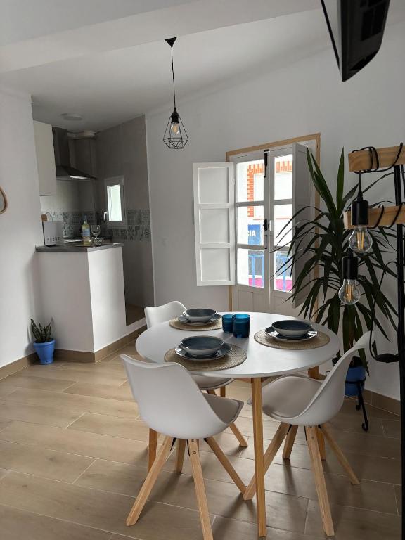a table and chairs in a room with a kitchen at Alaire Alojamiento in Algodonales