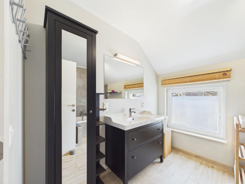 ein Badezimmer mit Waschbecken und Spiegel in der Unterkunft Chez Isaline Libin in Libin