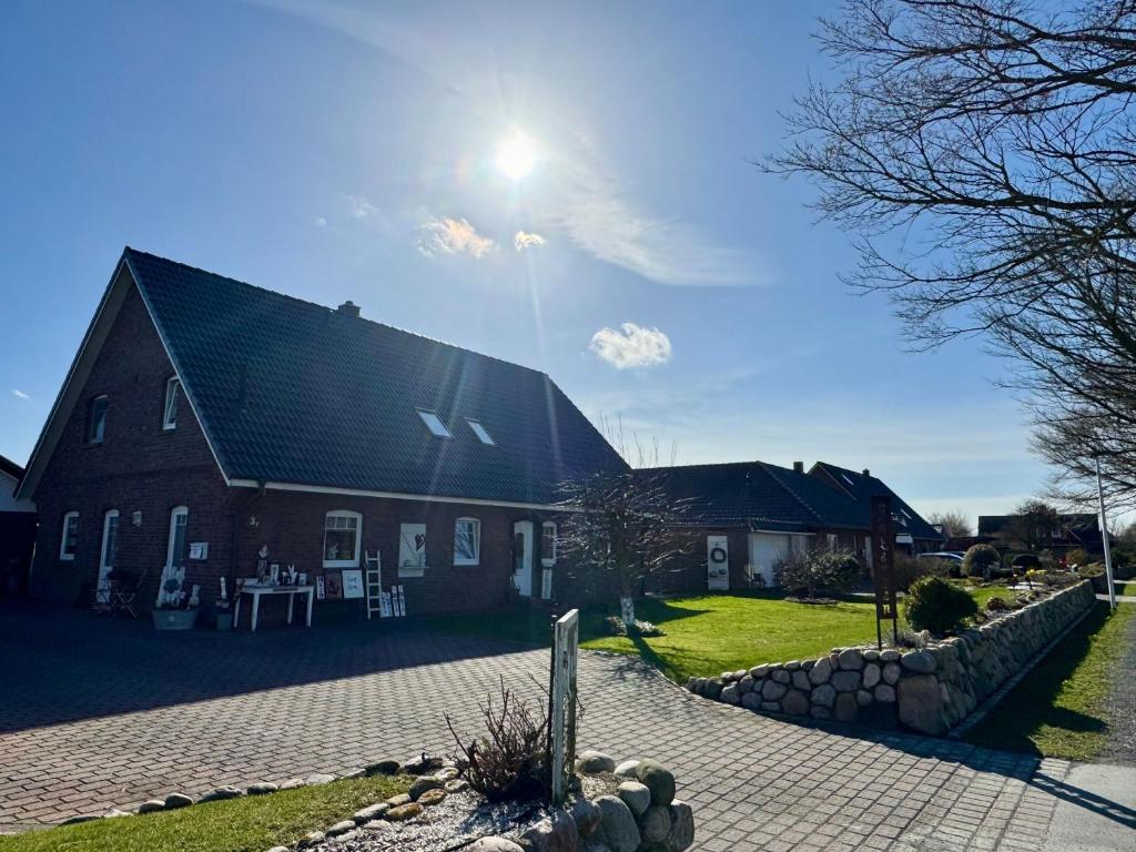 a large barn with the sun shining on it at Ferienwohnung Petersen in Nordstrand