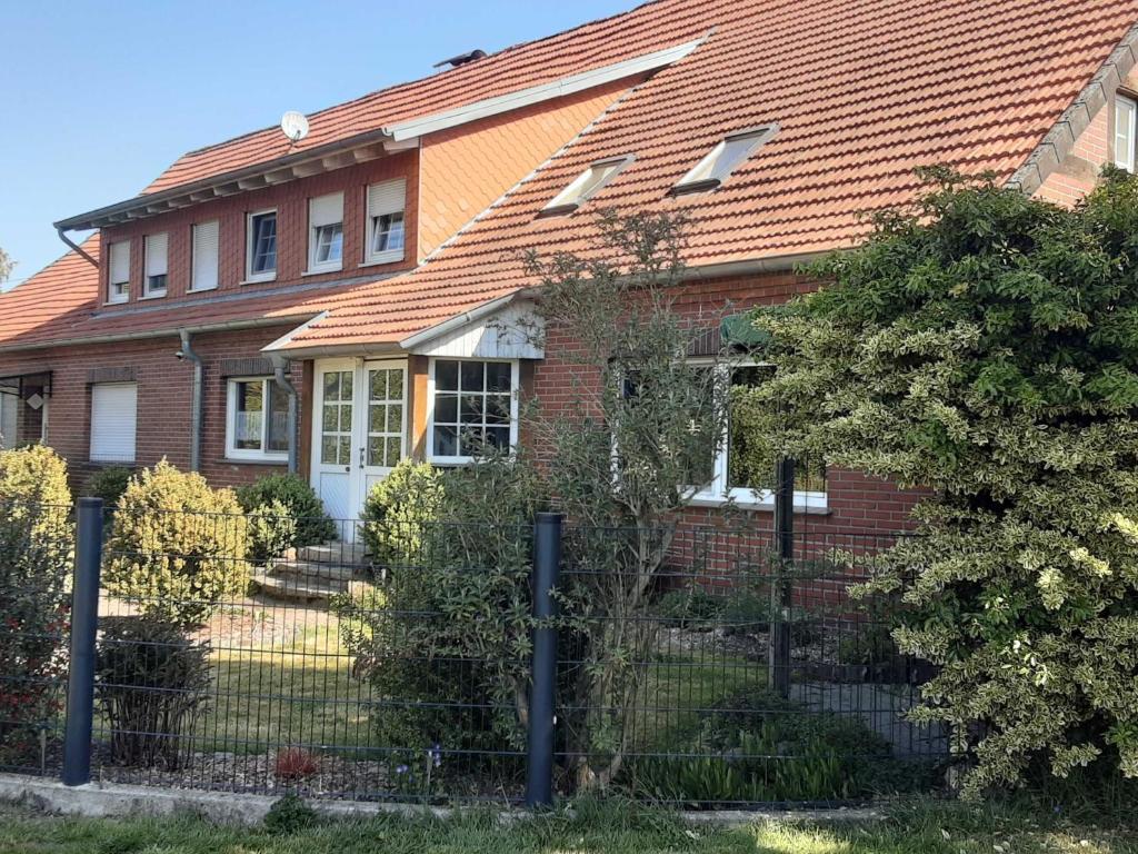 a red brick house with a fence in front of it at Ferienwohnung Loose in Tecklenburg
