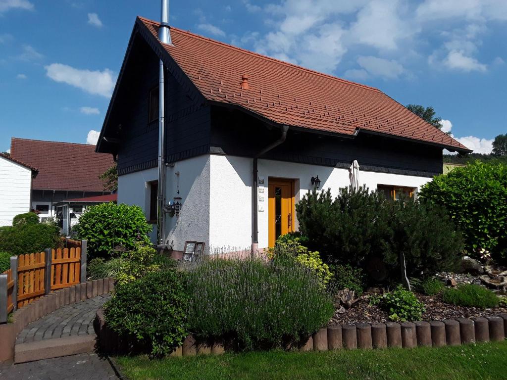 a small white house with a red roof at Haus Gemütlichkeit in Schotten