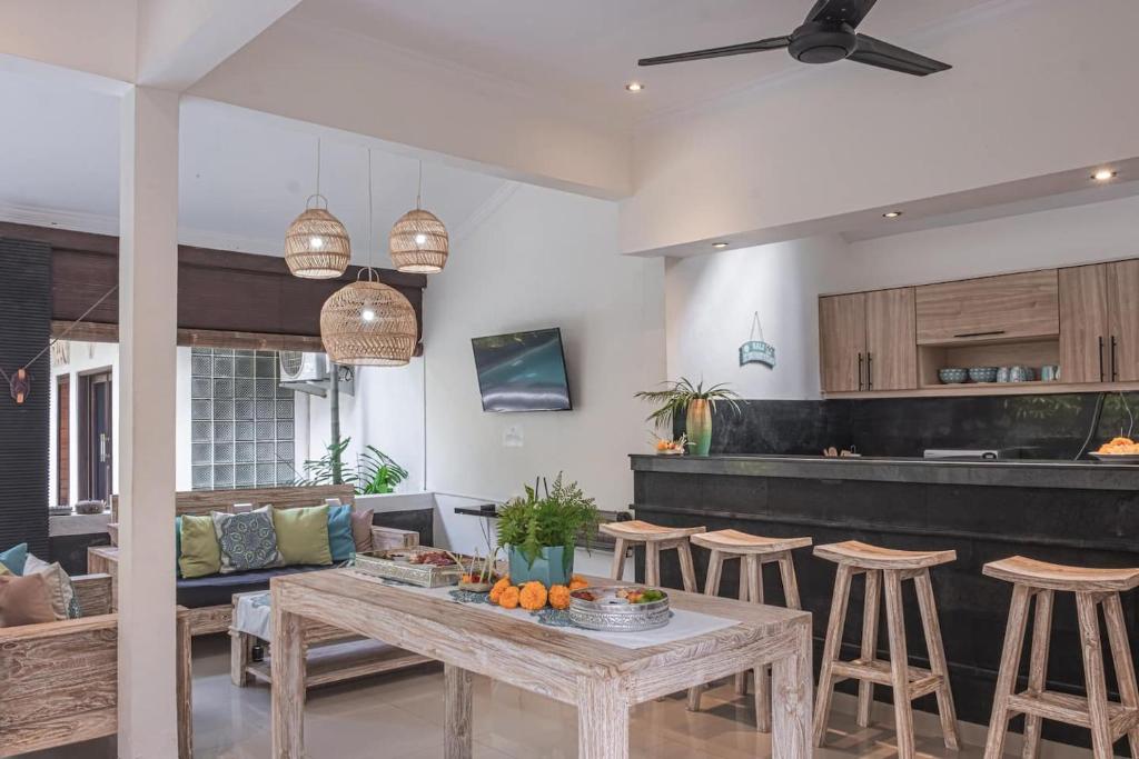 a living room with a table and some stools at Villa Karma Legian in Legian