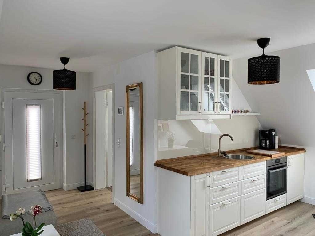 a kitchen with white cabinets and a sink at Haus Lindenstraße 3 in Beckdorf