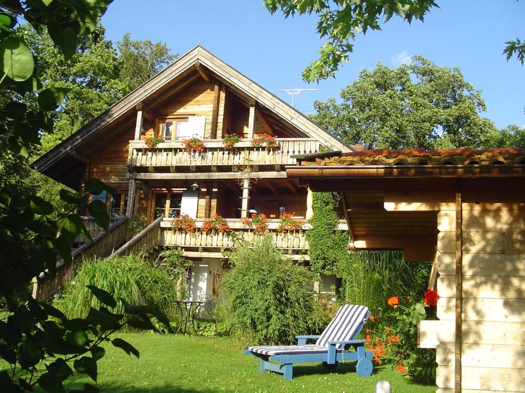 a house with a balcony and a bench in the yard at Ferienwohnung Kugler in Grafrath