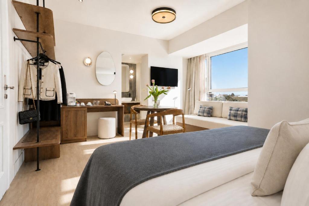 a bedroom with a bed and a desk and a mirror at Metaxa Hotel Heraklion - Urban Boutique Living in Heraklio