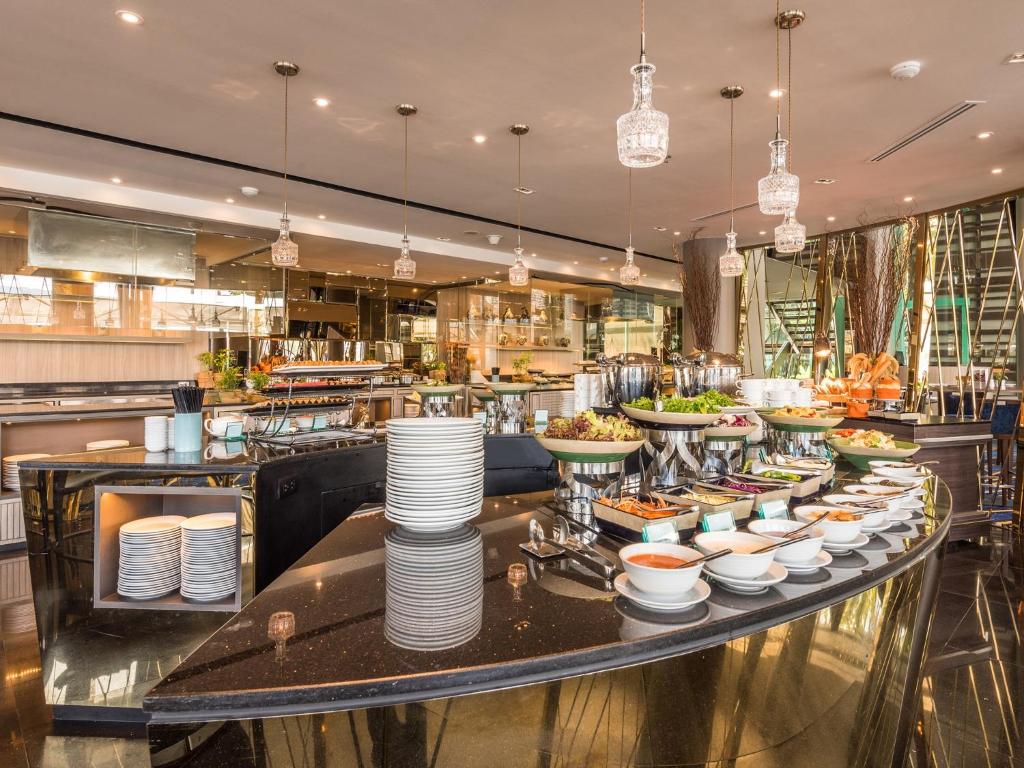 A broad restaurant buffet with serving bowls, stacked plates and several food stations.