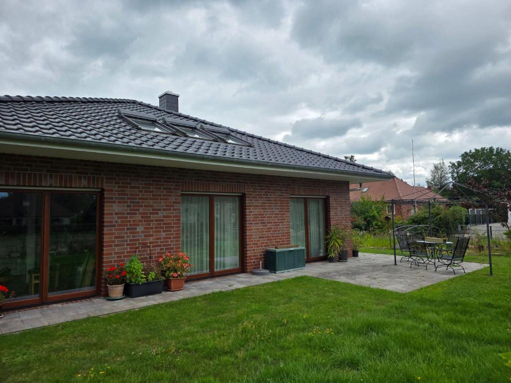 a brick house with a patio in a yard at Haus Gartenglück in Barßel
