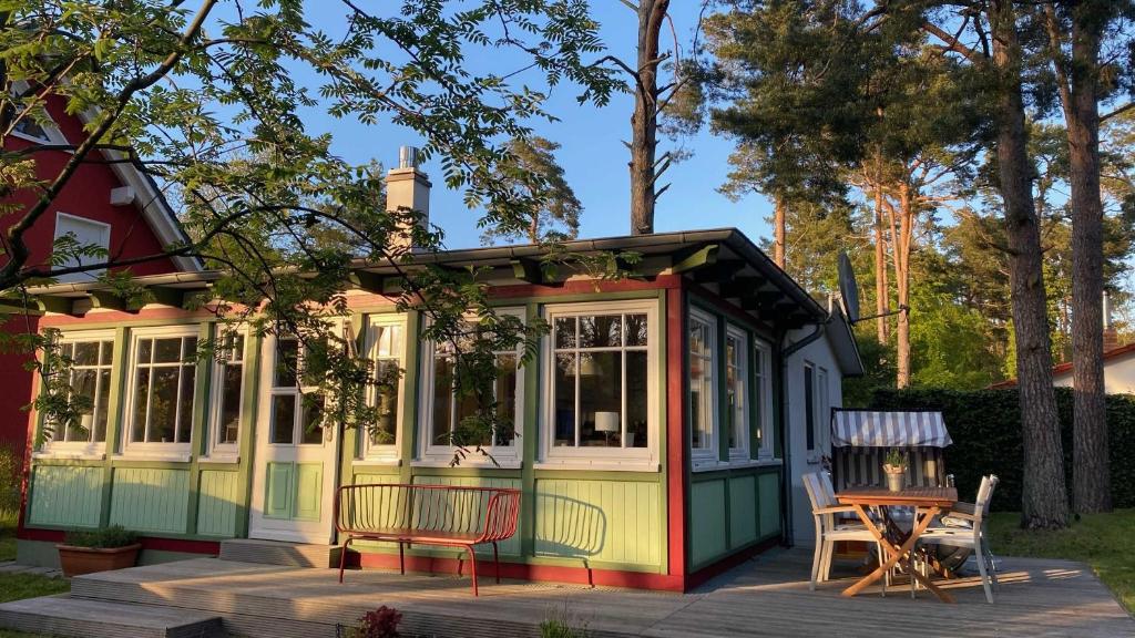 a tiny house with a table and chairs on a deck at Ferienhaus Kienhus in Graal-Müritz