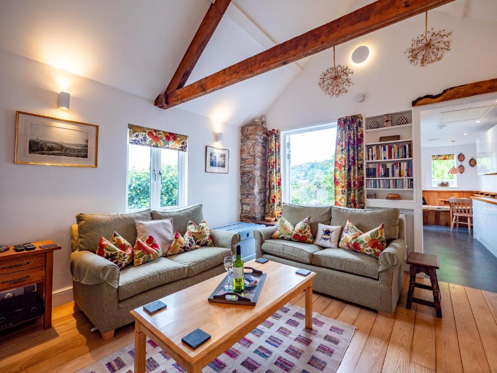 a living room with two couches and a table at Stylish Reverse-Level Retreat for couples in Totnes