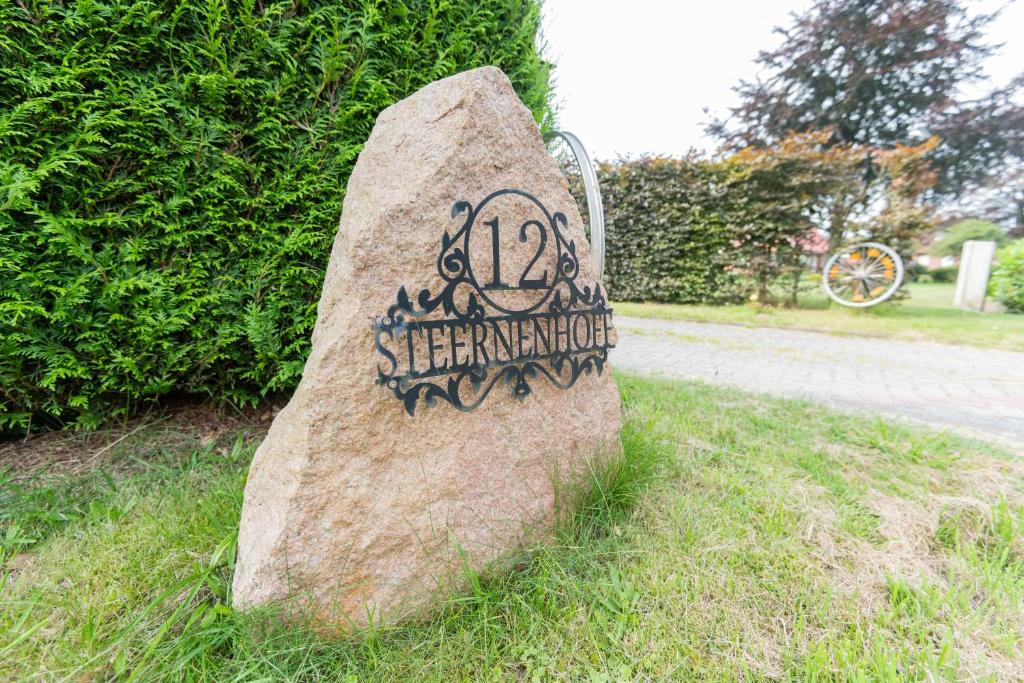 a rock with a sign on it in the grass at Ferienwohnung Eulennest, 35230 in Schwerinsdorf