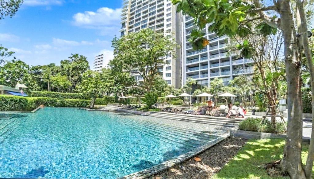 a swimming pool in front of a tall building at Zire WonAmat - Luxury Large One BR Seaview Apartment, Pattay beach in North Pattaya