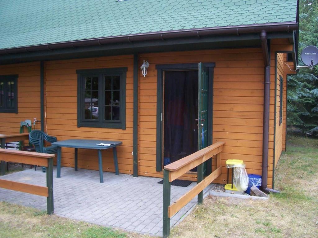 a small cabin with a picnic table and a patio at FH am Haff B in Altwarp