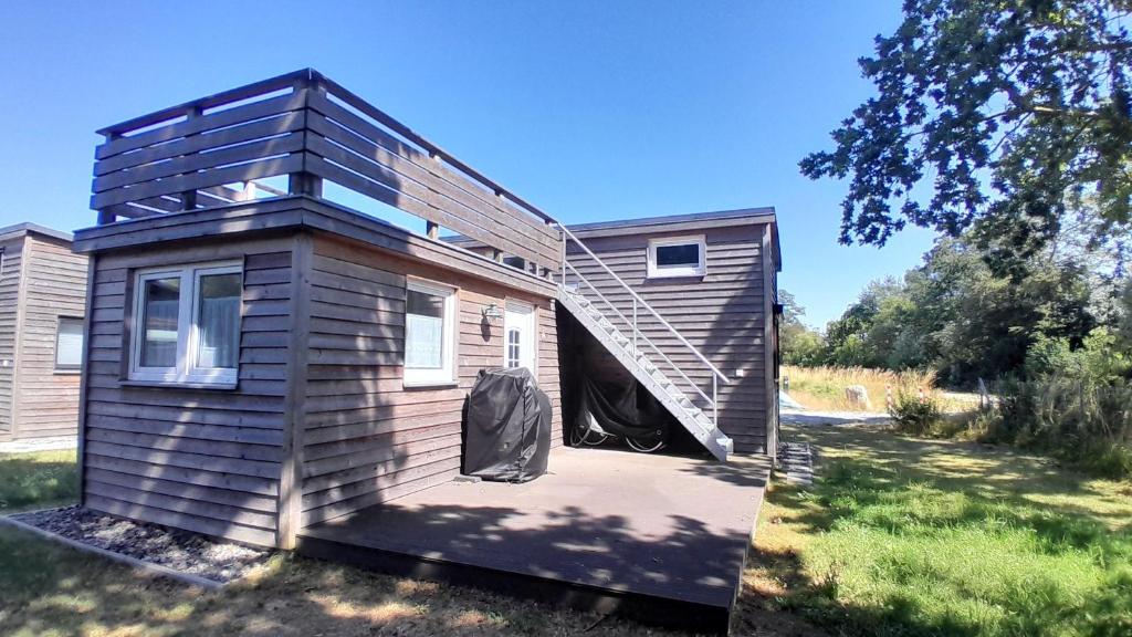 a house with a staircase on the side of it at Tiny Haus C235 Wacholderdrossel in Groß Kordshagen