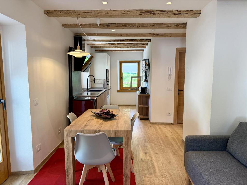 a kitchen and living room with a wooden table and chairs at Alpine Grace in Falcade