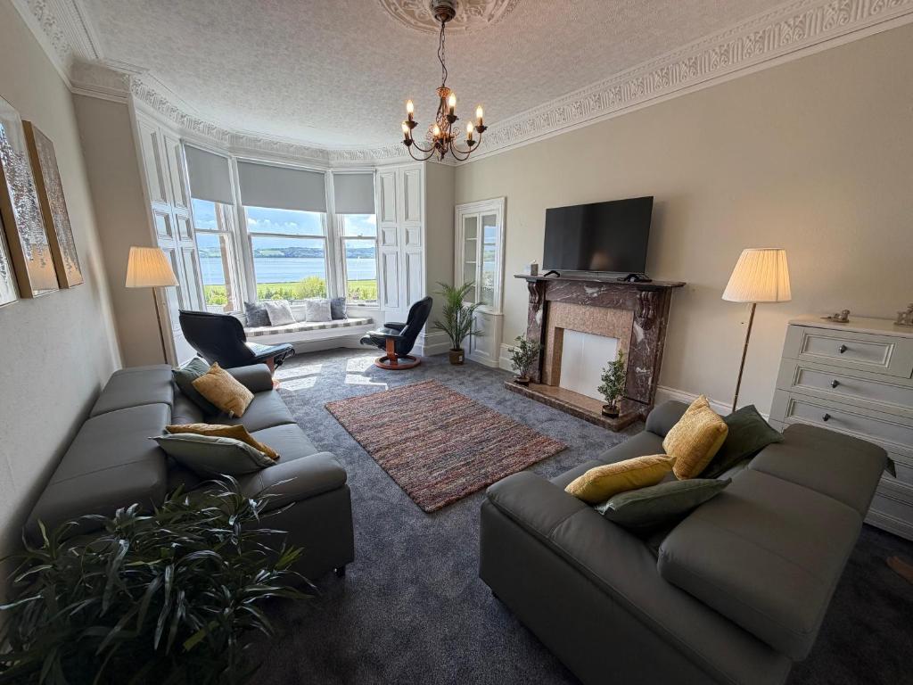 a living room with two couches and a fireplace at Prime Dundee West End 3BR Apartment, Stunning River Views, Sleeps 6 in Dundee