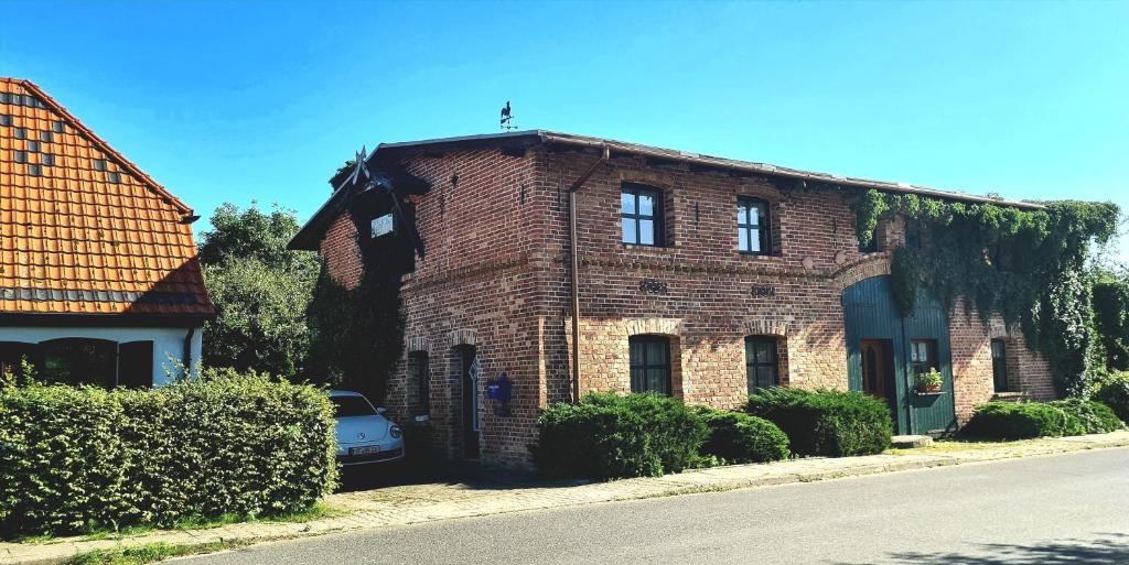 a brick house with a car parked in front of it at Fewos Storchenhof am Kummerower See in Meesiger