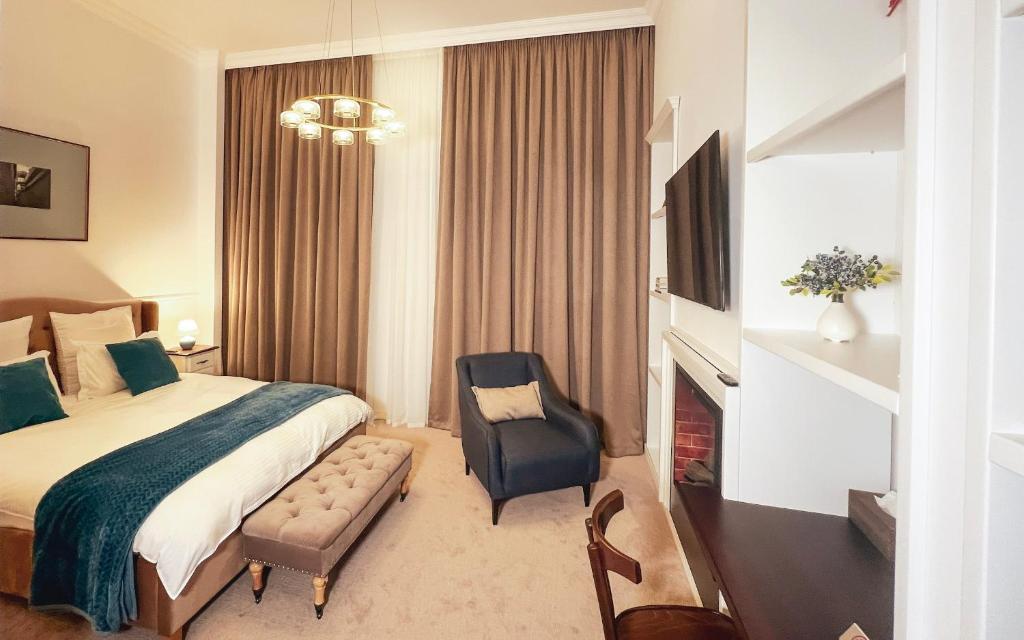 a hotel room with a bed and a chair at Weiss Central Boutique in Braşov