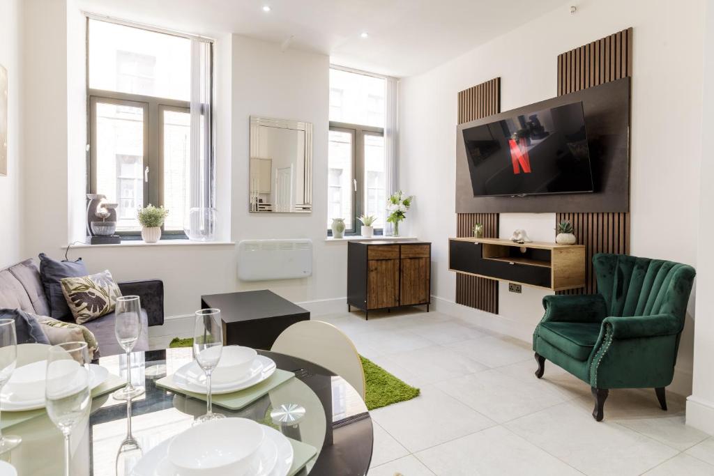 a living room with a table and a tv at Modern City Centre Ground Floor - Apt 6 in Bradford