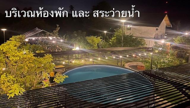 a view of a swimming pool at night with lights at Baan Suan Papa Resort Wangmuang in Ban Nong Lom (1)