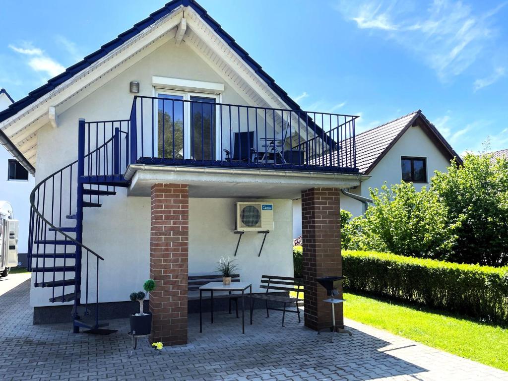 a small white house with a balcony and a table at Gästehaus Seenland in Lauta