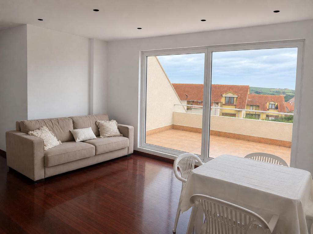 a living room with a couch and a table at Atico con terraza al mar in Mogro