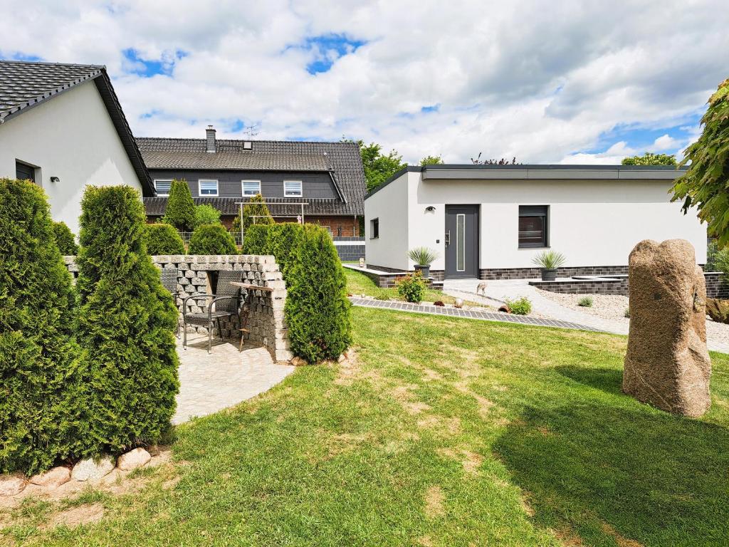 a yard with bushes and a house at Ferienhaus "Laila" ID 16019-2 in Möllenhagen