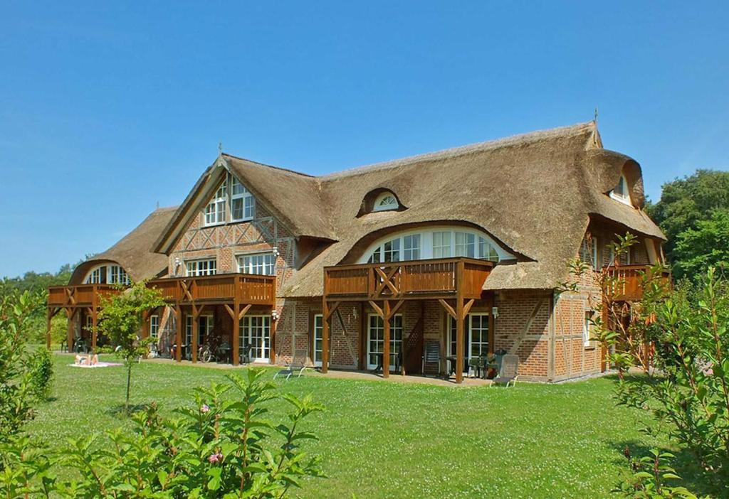 a large house with a thatched roof at Haus an der Düne Whg 10 in Lobbe
