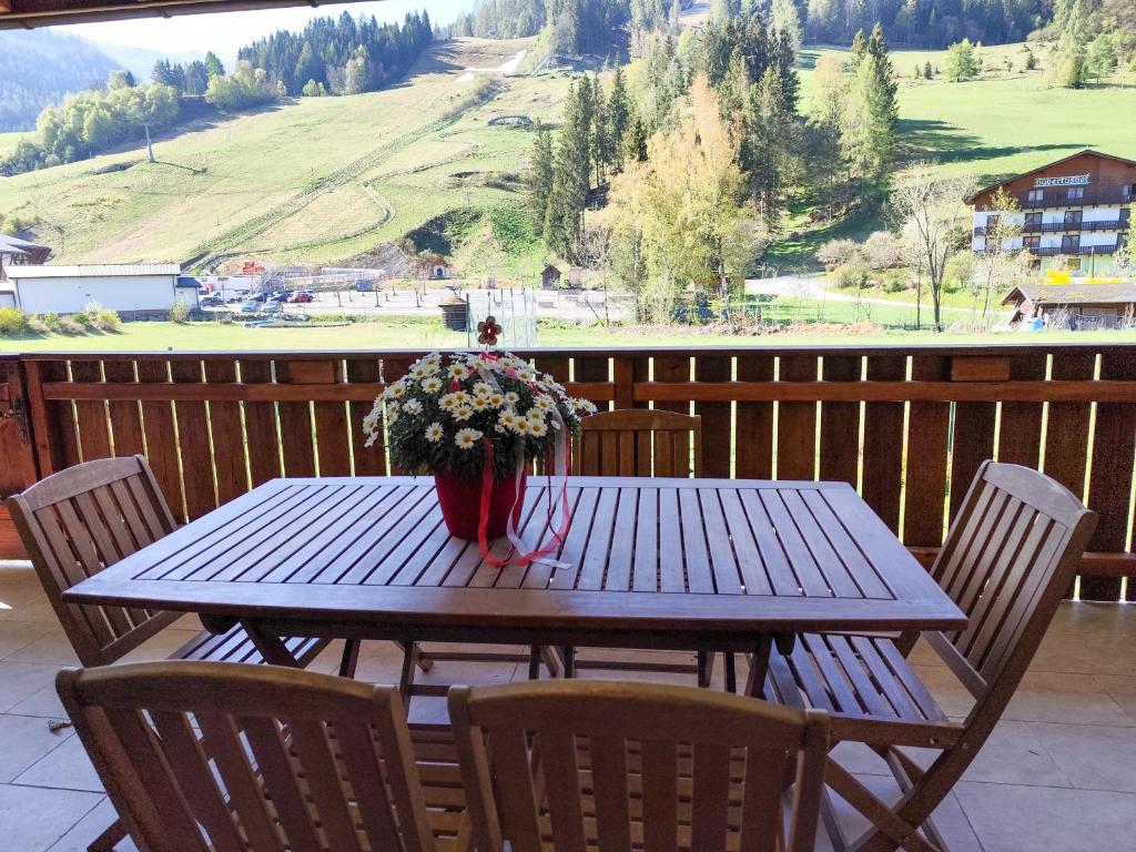 a wooden table with a vase of flowers on it at Appartements Bel Monte - Kärnten Card im Sommer inklusive in Bad Kleinkirchheim