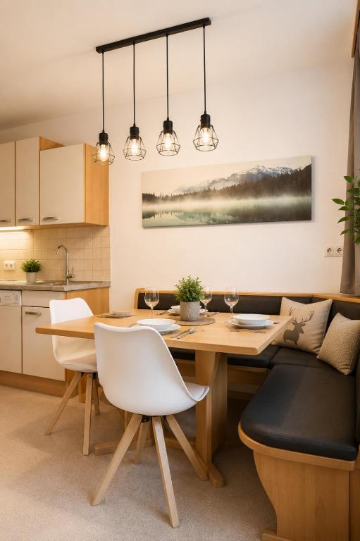 a kitchen and dining room with a wooden table and chairs at Appartement zur Gemütlichkeit - Ski Juwel im Alpbachtal in Wörgl