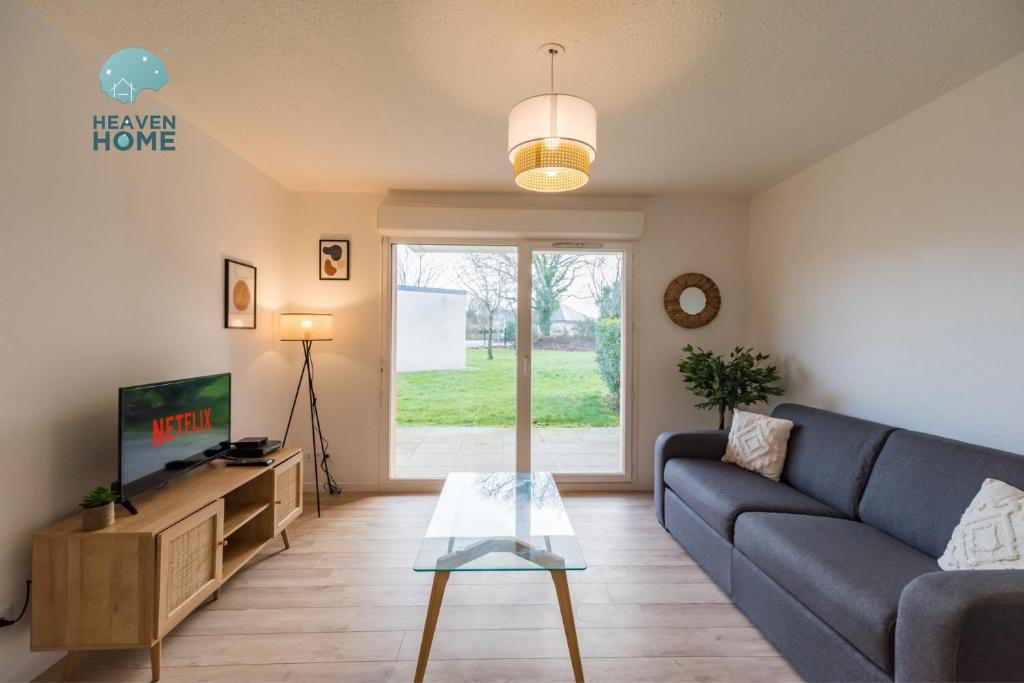 a living room with a couch and a tv at Appartement neuf proche Guingamp in Ploumagoar