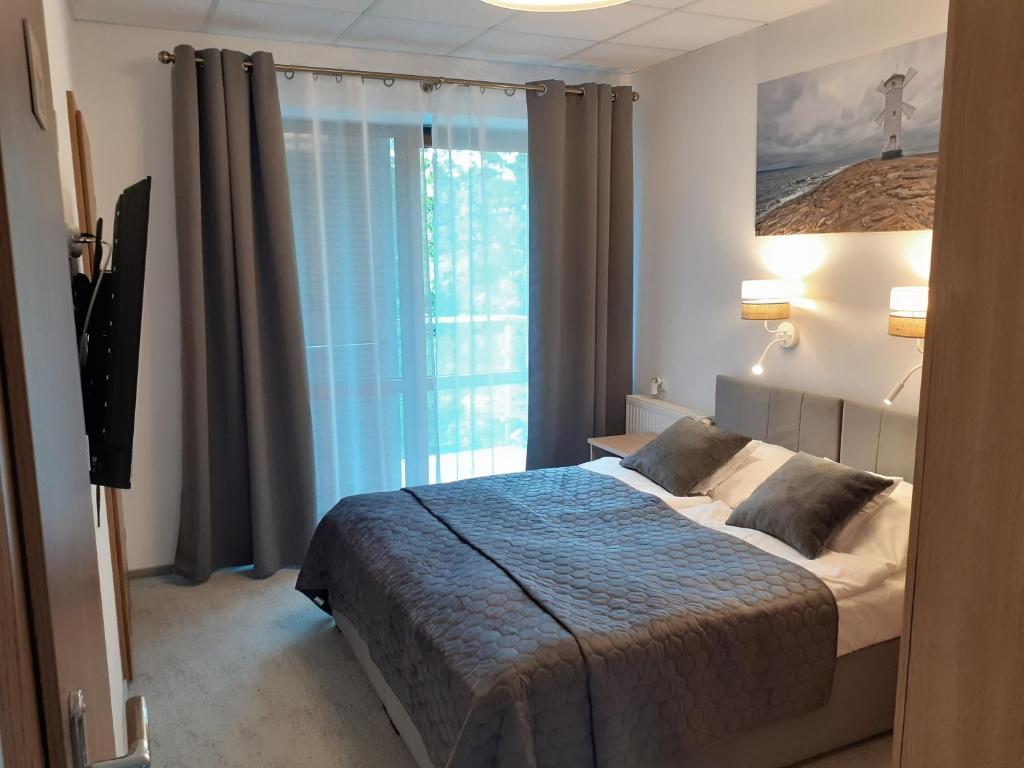 a bedroom with a bed and a large window at Ośrodek Warszawianka in Świnoujście