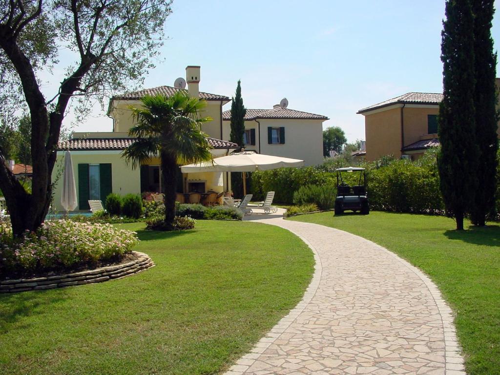 a walkway leading to a house with an umbrella at Scirocco in Isola Albarella